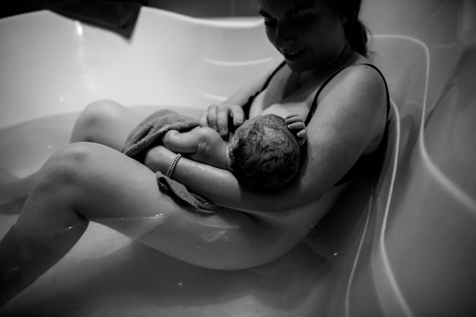 a mother holds her baby in the tub at Edmonton's Lucina Birth Centre