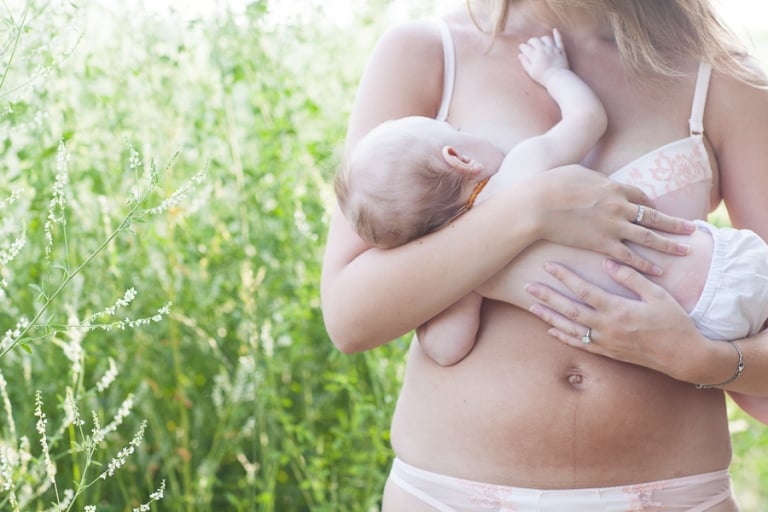 young mom breastfeeds her three month old daughter