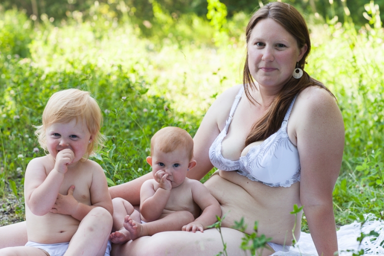 mom sits in her underwear with her two red-haired daughters as they suck their thumbs