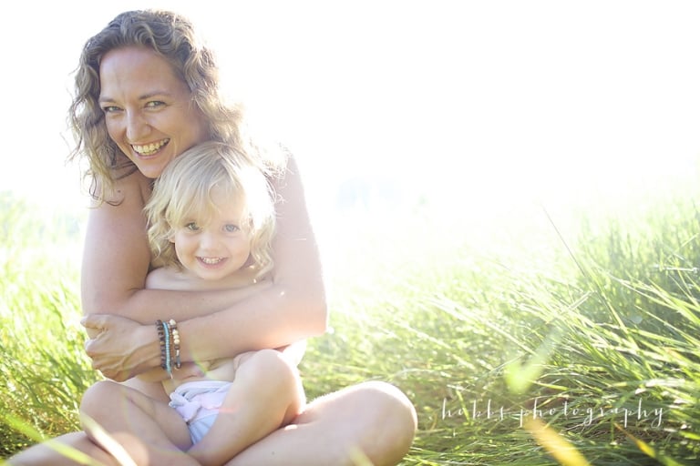 happy mother and daughter cuddle outside