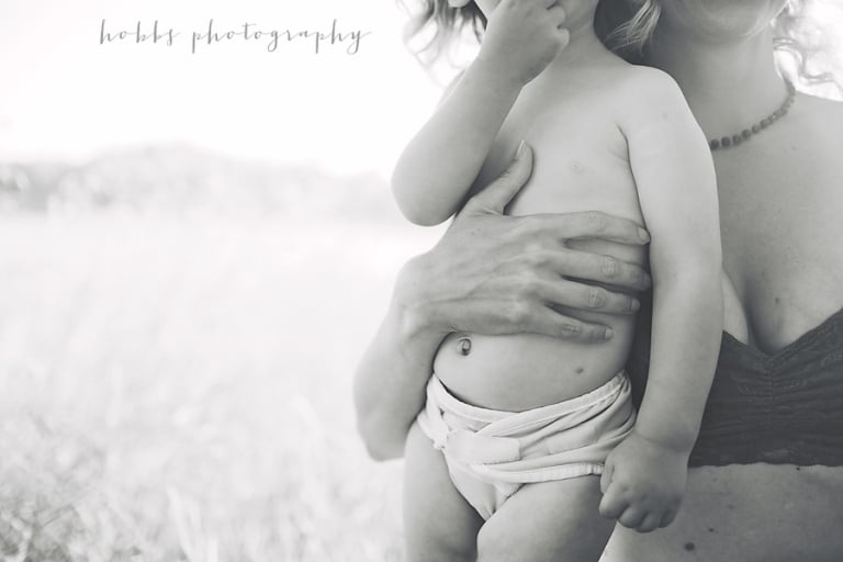 mom gently embraces her toddler for portrait
