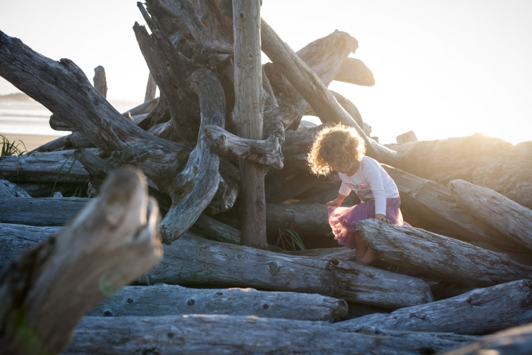 Edmonton family photographer captures honest portrait of child playing in driftwood at Tofino beach