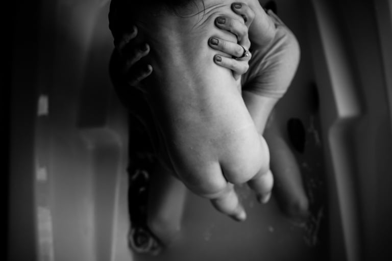 black and white portrait of baby bum during milk bath session