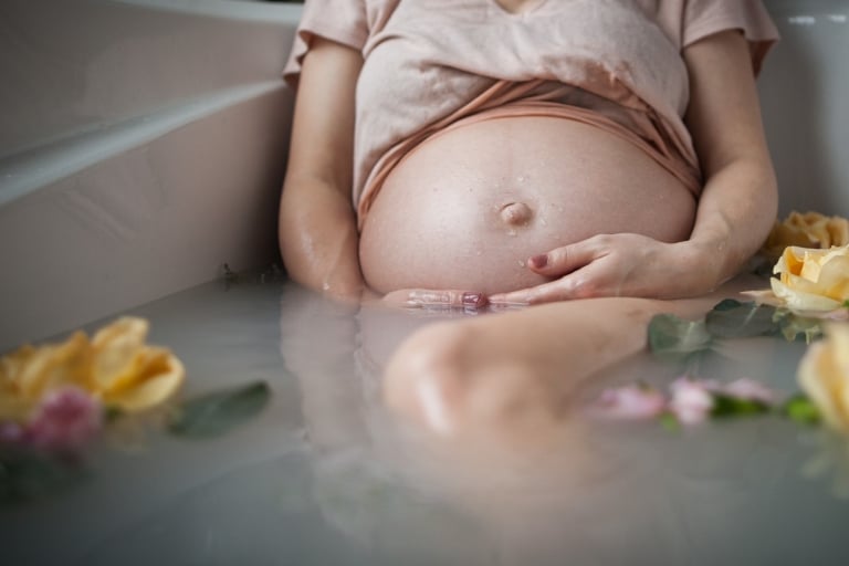 water drips on mom's tummy during her maternity session by Jenna Hobbs