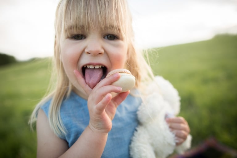 authentic portrait of child eating a cookie holding her stuffy