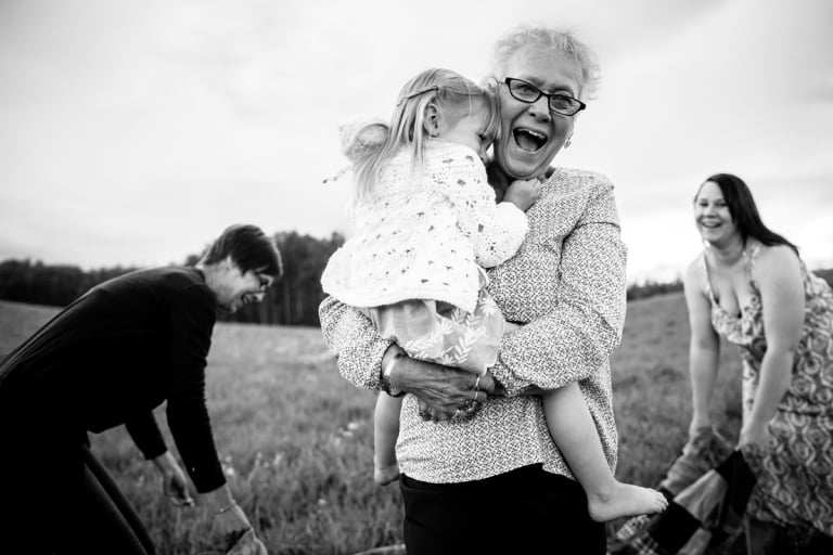 great grandmother laughs with her family in beautiful session with four generations of women