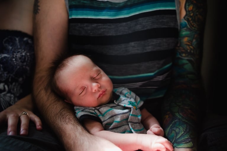 baby lays in dad's arms in their St. Albert home