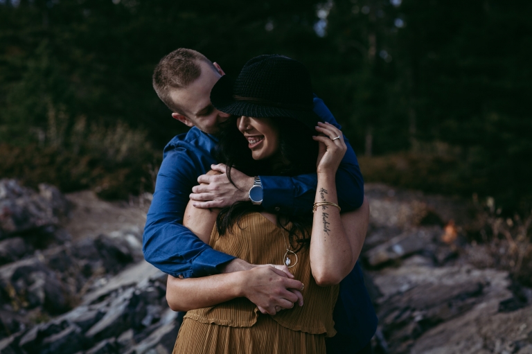 groom hugs his future bride in mountain engagement pictures