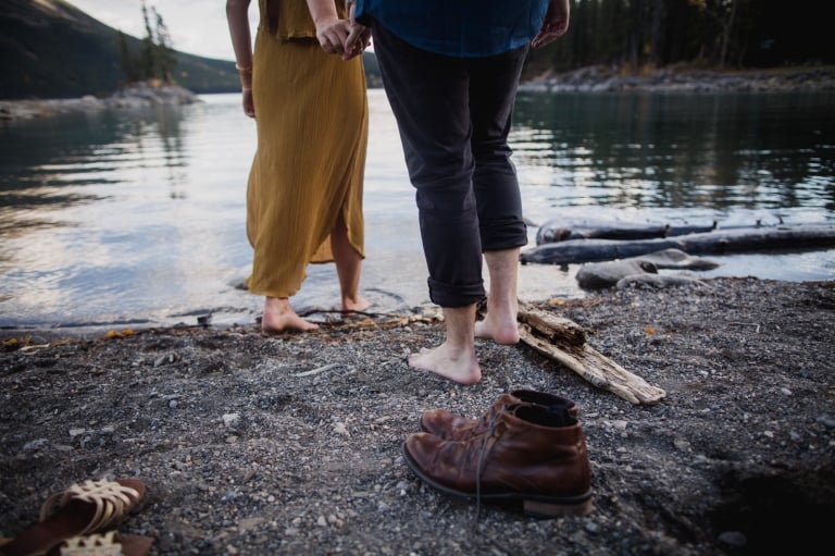 adventurous couple head into Lake Minnwanka during their engagment pictures In Banff National Park