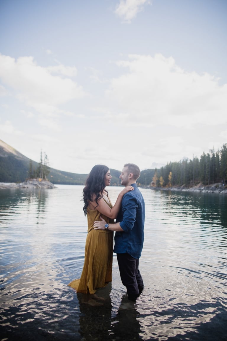 couple walks into lake Minnwanka in Banff National Park