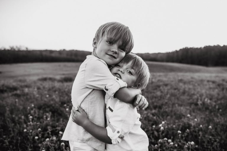 two brothers hug during lifestyle family photography session by Edmonton photographer
