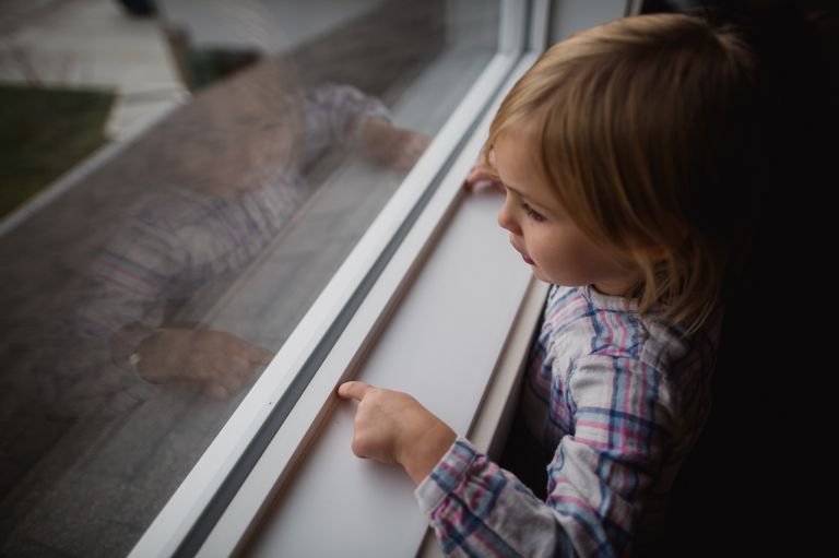 girl looks out window in fort saskatchewan