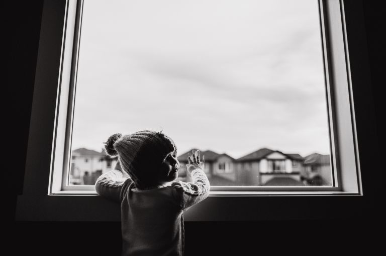 littel girl leaves fingerprints on the window