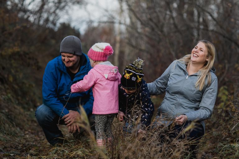 family plays outside in the fall leaves