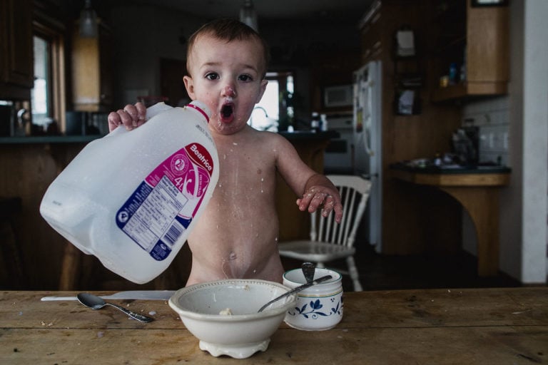 toddler exclaims with surprise as he spills milk