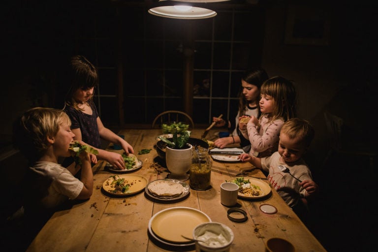 five kids sit around the table for supper