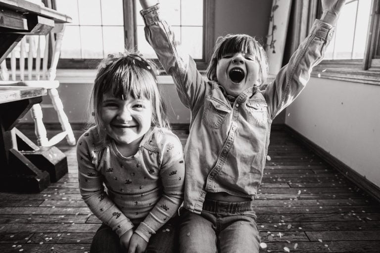 sisters laugh and smile as they play with confetti