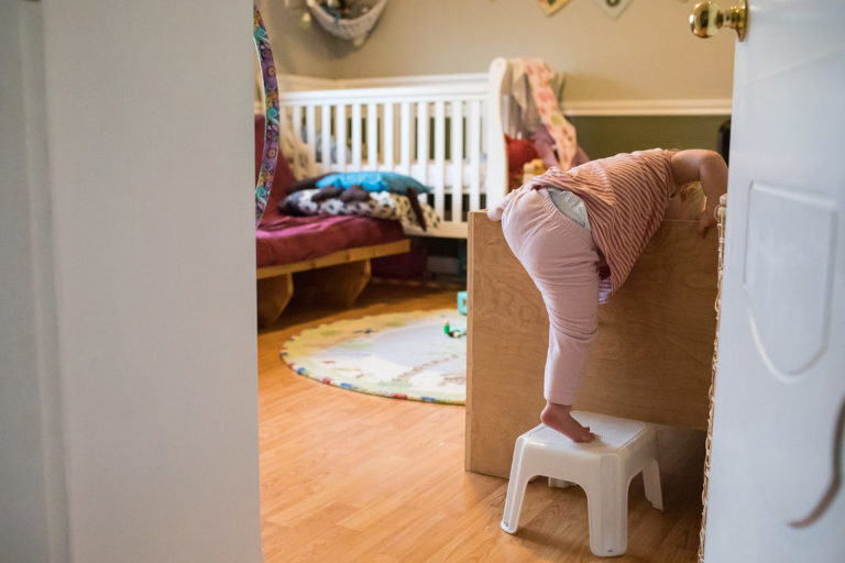 toddler uses stool to climb into her sister's bed by herself