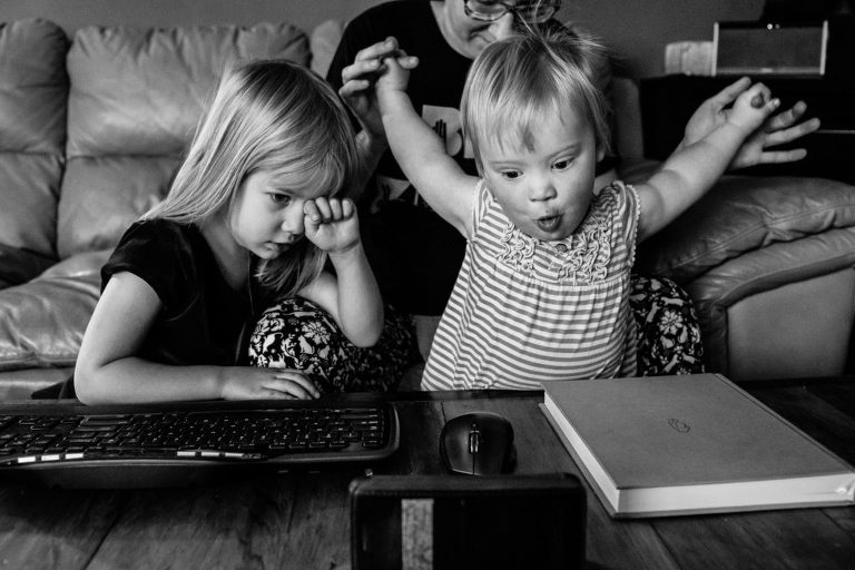 sisters watch a video on an iphone