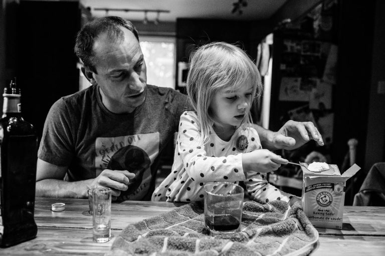father and daughter attempt a science experiment at the kitchen table