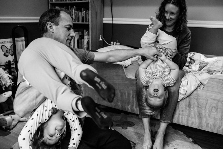 mom and dad play with their daughters in their home