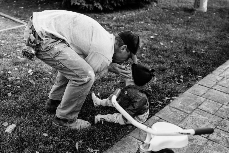 dad gives his sick toddler a kiss during a work break