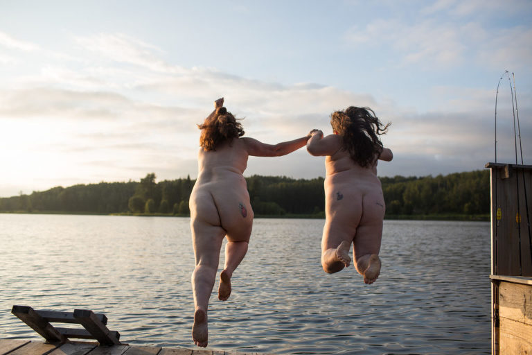 two moms holds hands and jump naked off the dock near Edmonton