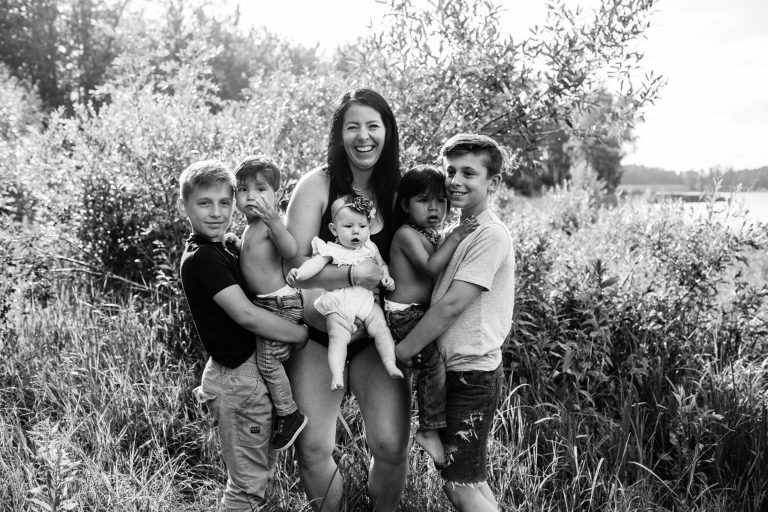 mom has fun black and white portrait with her adopted, foster and biological children