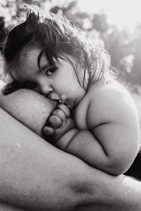 postpartum photography of baby breastfeeds from standing mother
